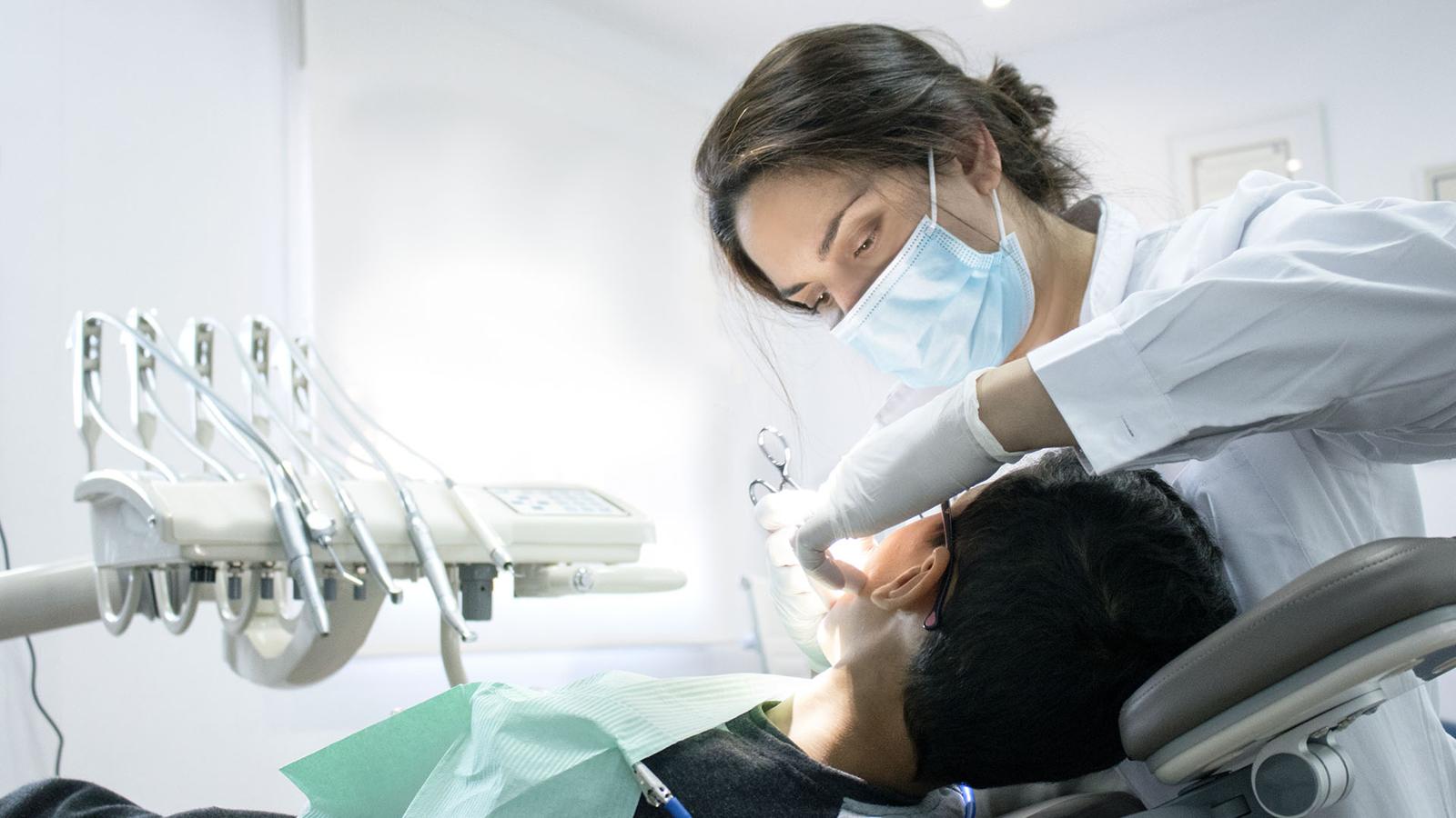 Doctora tratando a un paciente en el gabinete dental